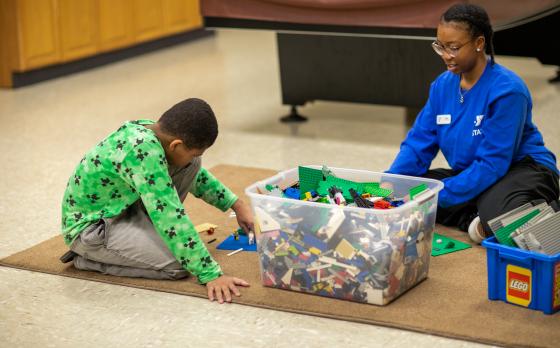 a child and ymca staff member playing with legos