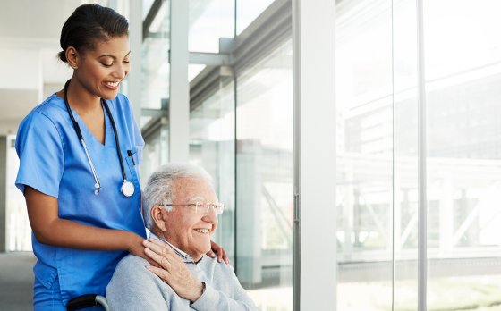 Elderly person in wheel chair with medical professional
