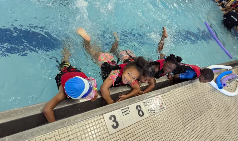 5 children swim together during the Summer LEAP program at the Maplewood Family YMCA
