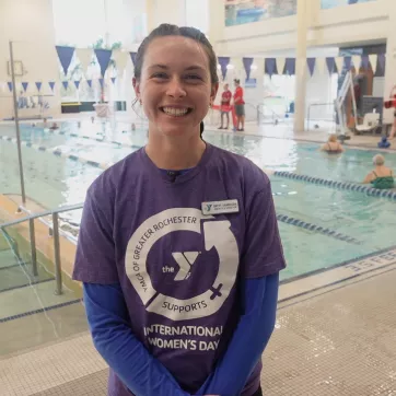 Westside Aquatics Director Brett VanBoden smiles and stands in front of the westside family ymca pool