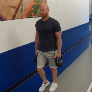 Corning Family YMCA member carrying kettlebell