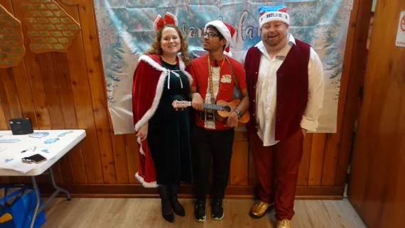 Two YMCA staff standing with a member at the Winter Wonderland Dance