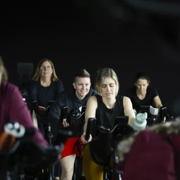 group of ymca members partake in cycle class, smiling