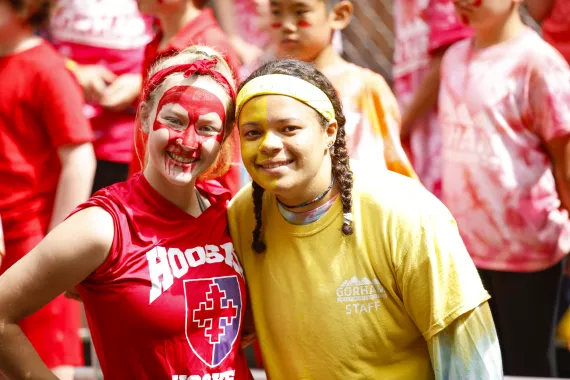 Two campers, left camper in all red with red face paint, right camper in all yellow with yellow face paint