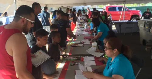 volunteers greet participants at the sign in table of a basketball tournament